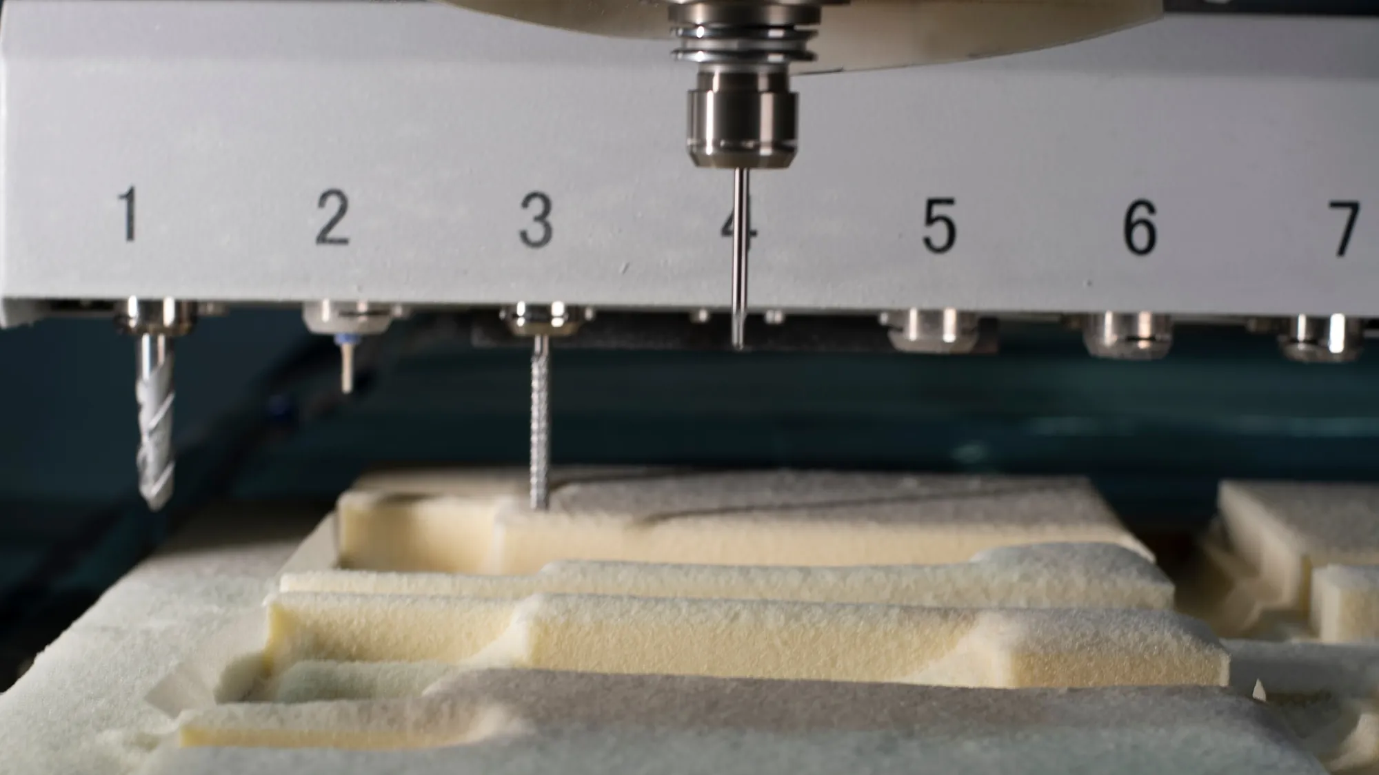 A CNC cutter shaping a propeller foam core, tool positions numbered along the gantry