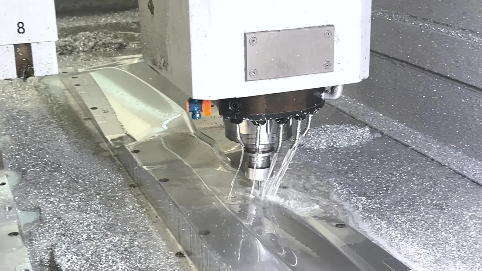A CNC cutter machining an aluminium propeller mold under running coolant