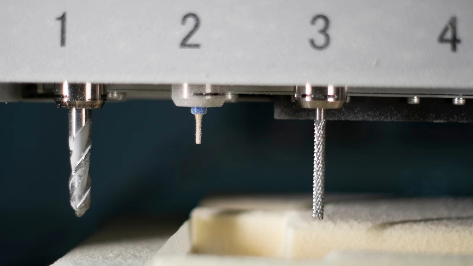 CNC machine shaping a propeller foam core, tool positions numbered on the bed