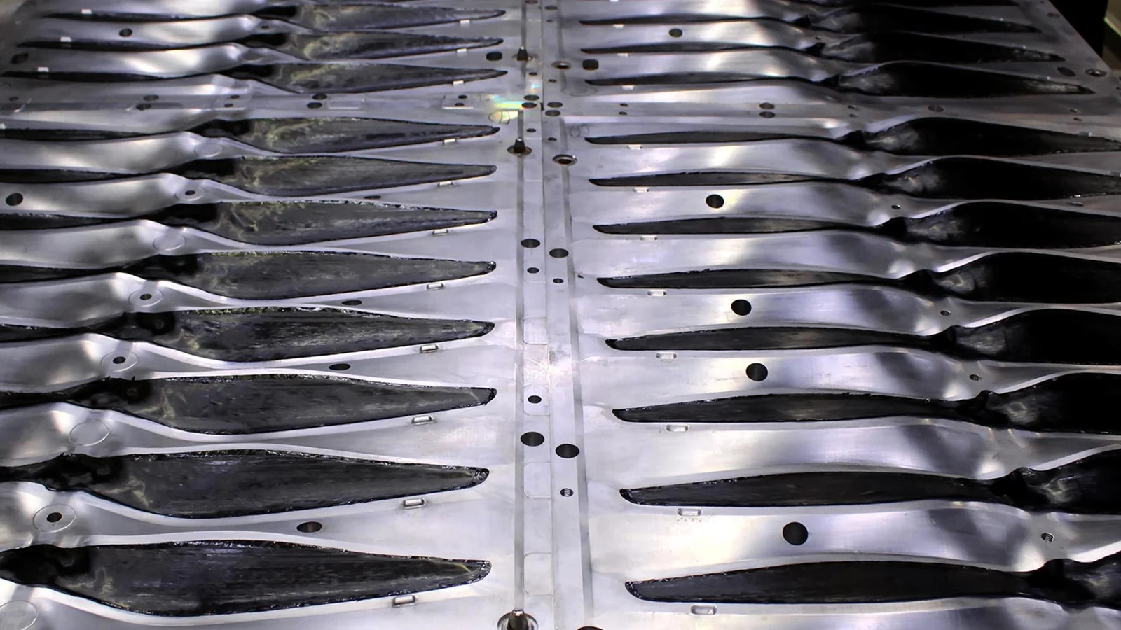 Carbon fiber plies laid into the blade cavities of an aluminium mold plate